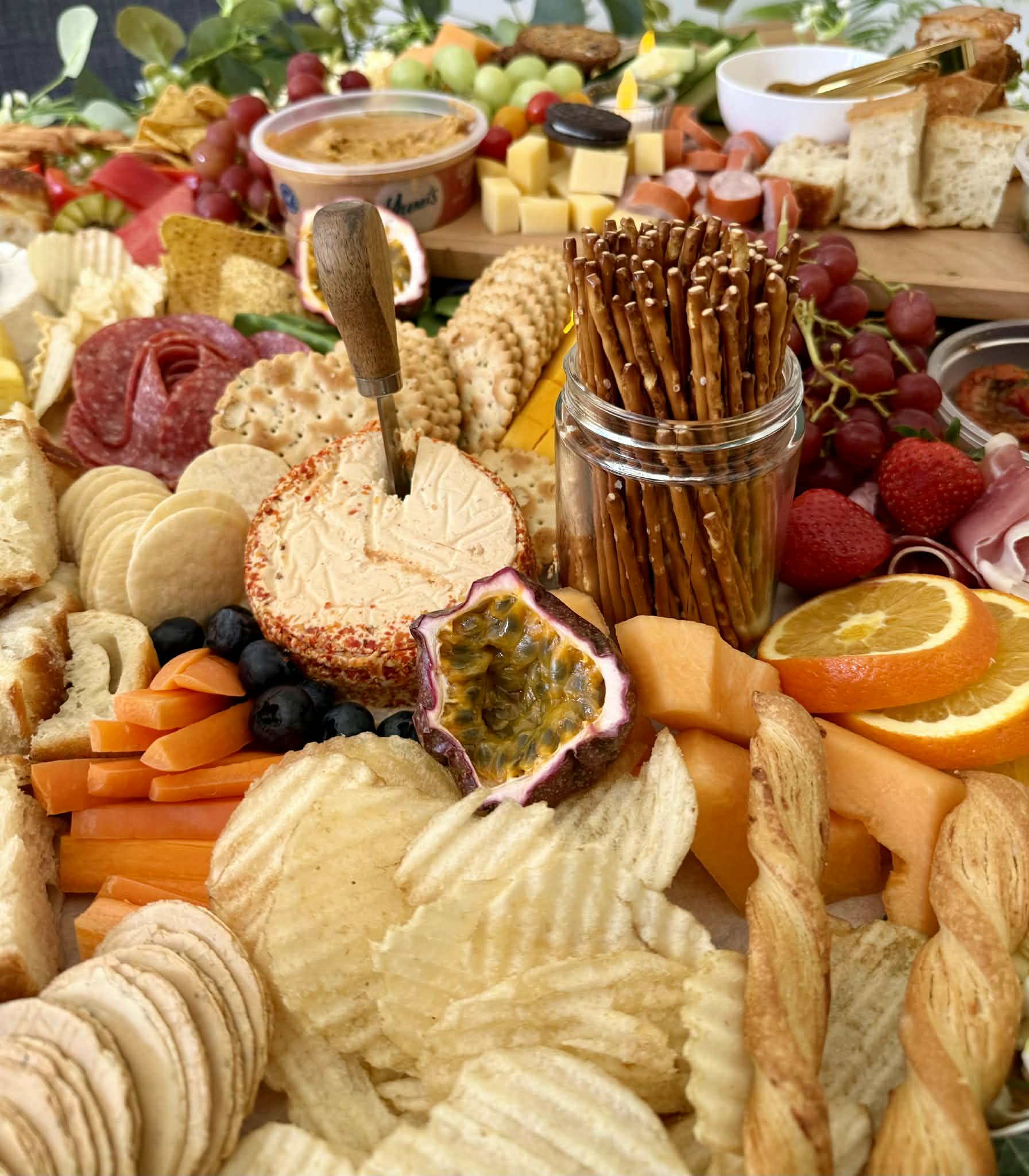 Close-up of artisan cheese wheel and pretzels